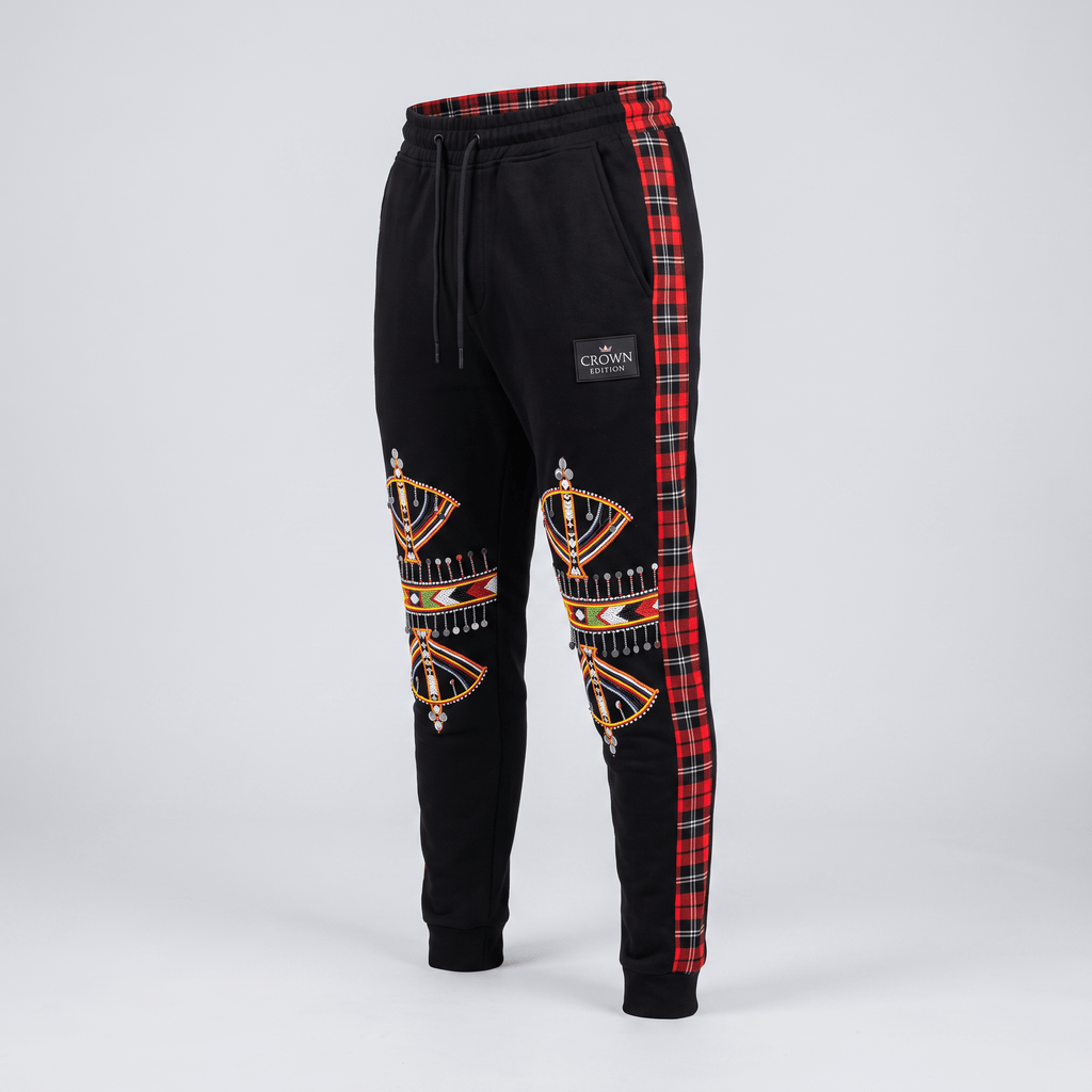 Black sweatpants featuring red tartan side stripes, colorful knee embroidery, and a Crown Edition label.