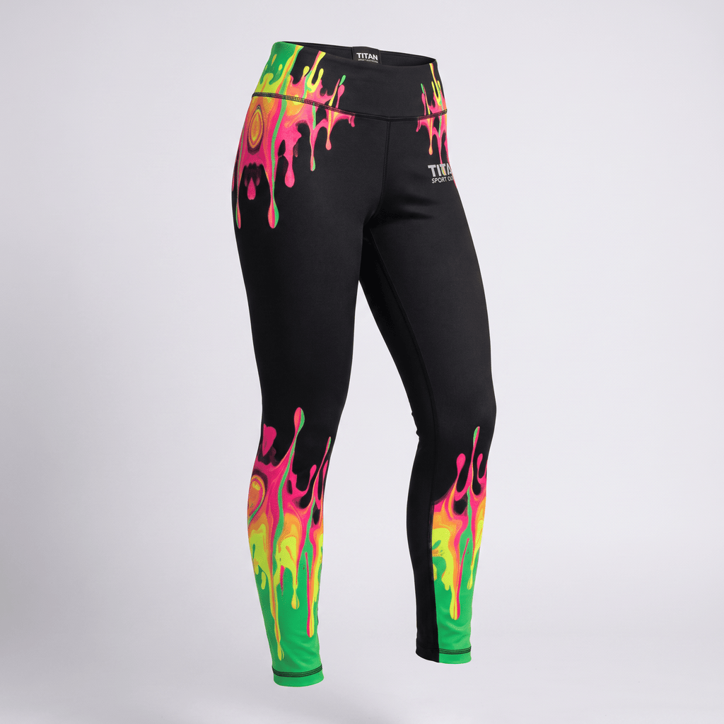 Black athletic leggings with vibrant neon pink and green paint drip print on the waistband and ankles.