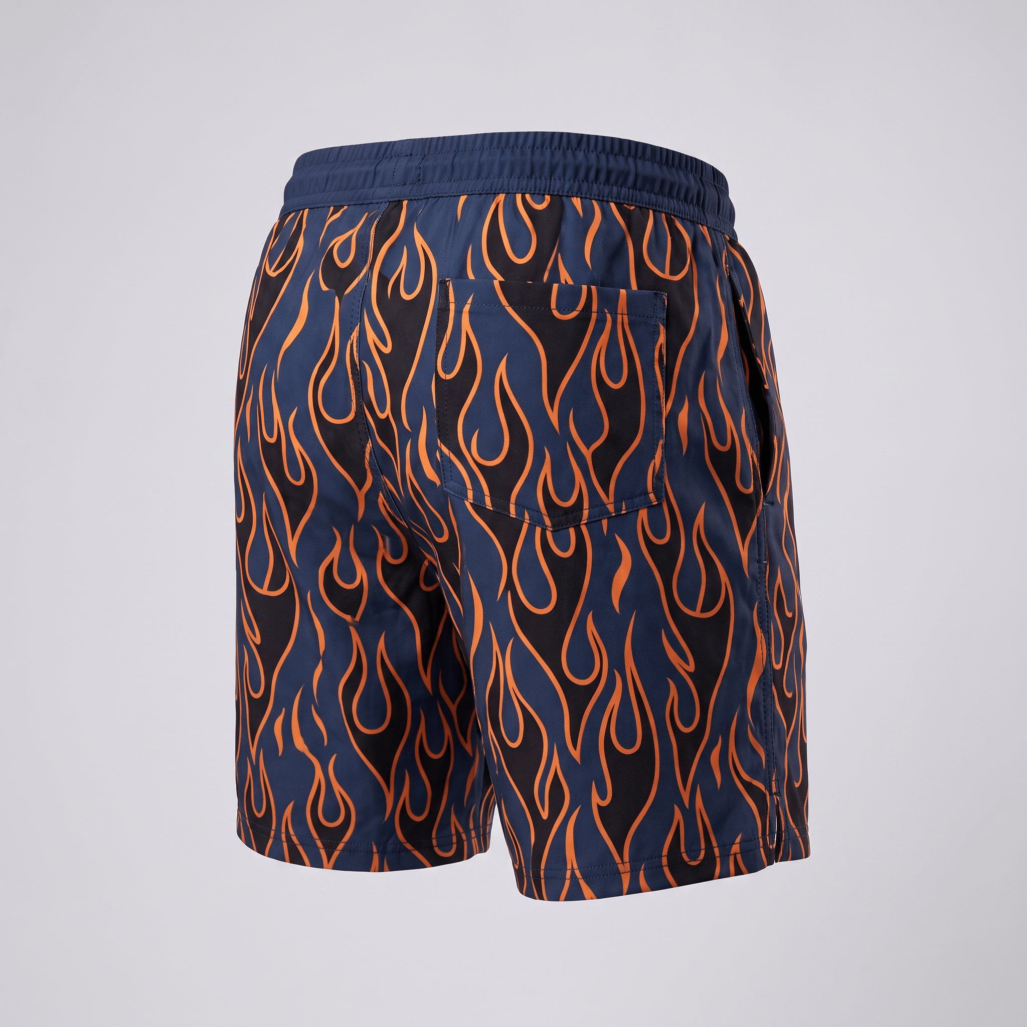 Back view of navy blue swim shorts with an orange flame pattern and back pocket.