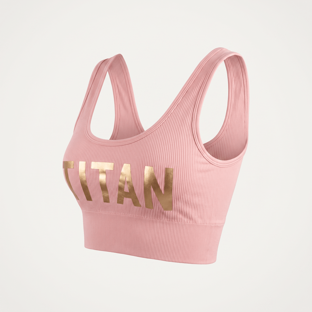Pink ribbed athletic sports bra featuring gold metallic Titan branding across the front.