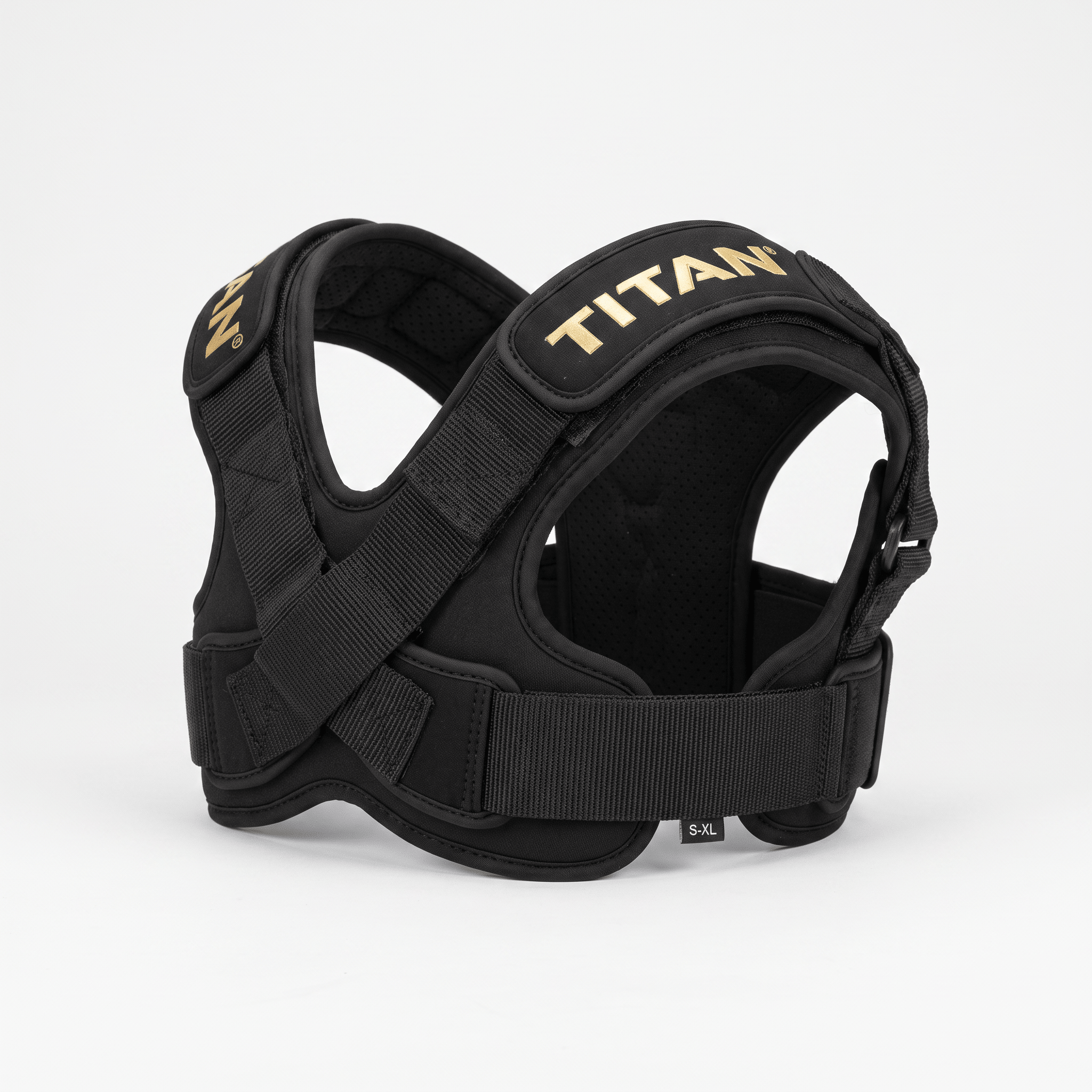Black Titan posture corrector harness with gold branding, padded straps, and adjustable buckles on white.
