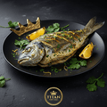 Grilled fish with chermoula, lemon wedges, and parsley on a black plate with a gold crown, against a dark background.