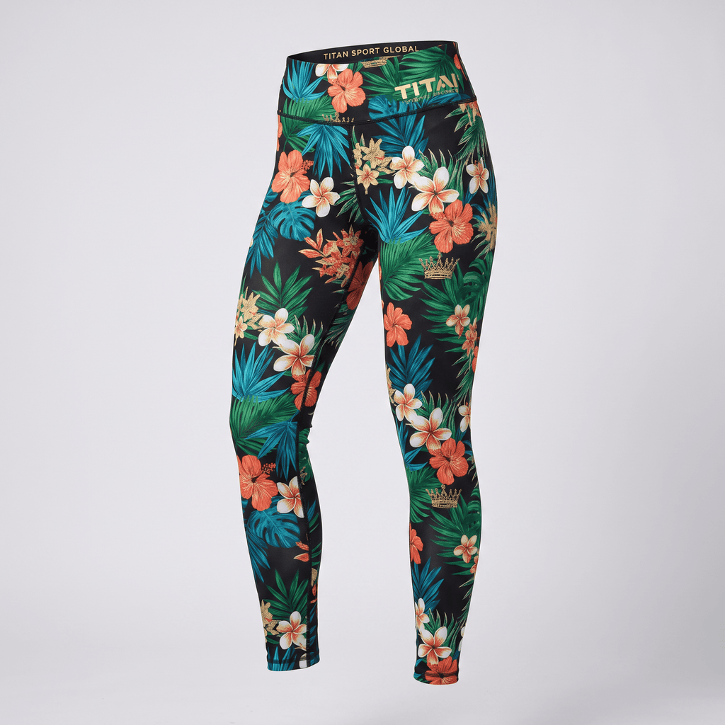 Black athletic leggings featuring a vibrant tropical floral print with green leaves and orange and white flowers.