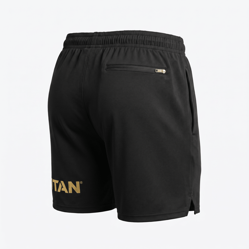 Rear view of black athletic shorts with gold branding on the leg and a zippered back pocket.