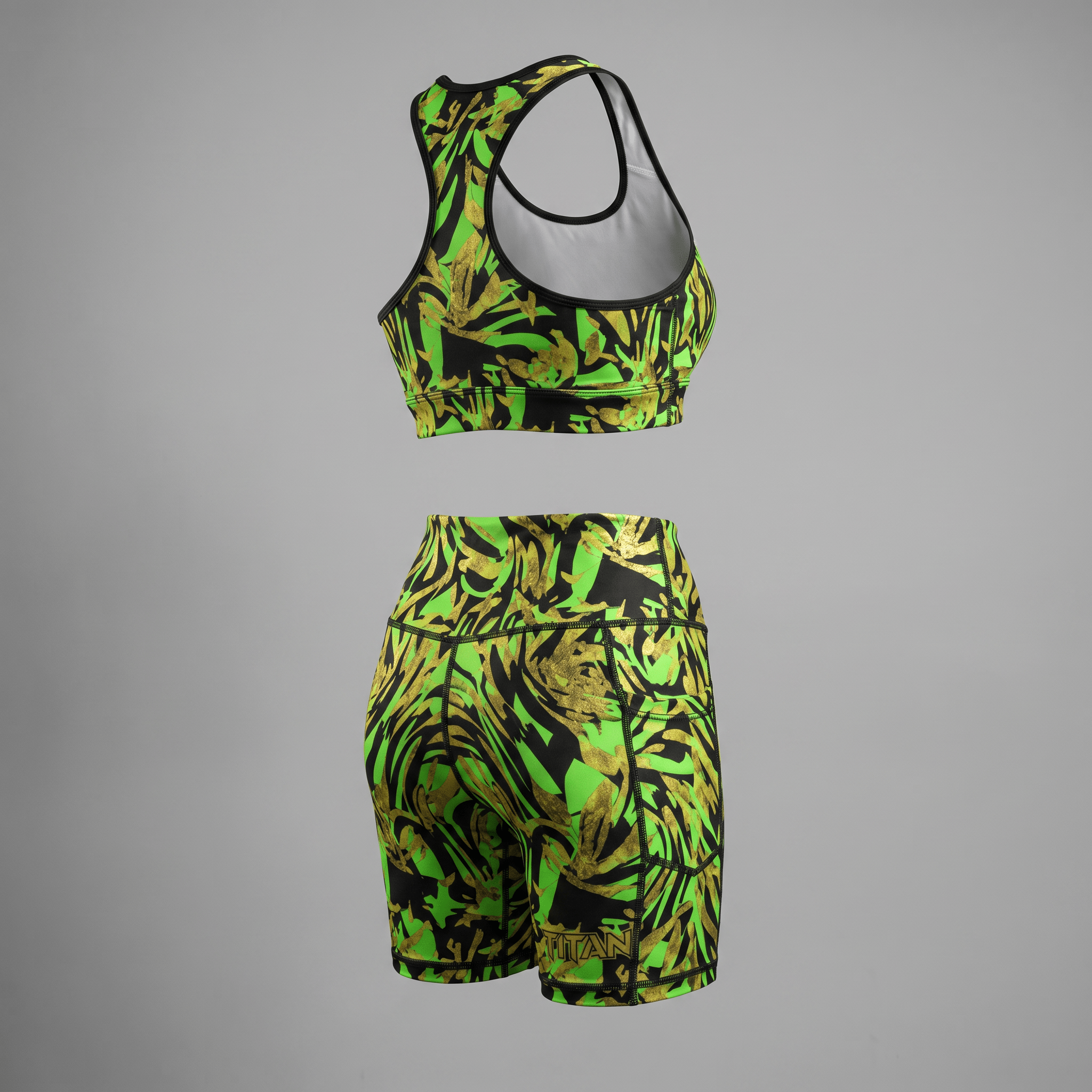 Back view of a green, black, and gold abstract print sports bra and high-waisted biker shorts activewear set.