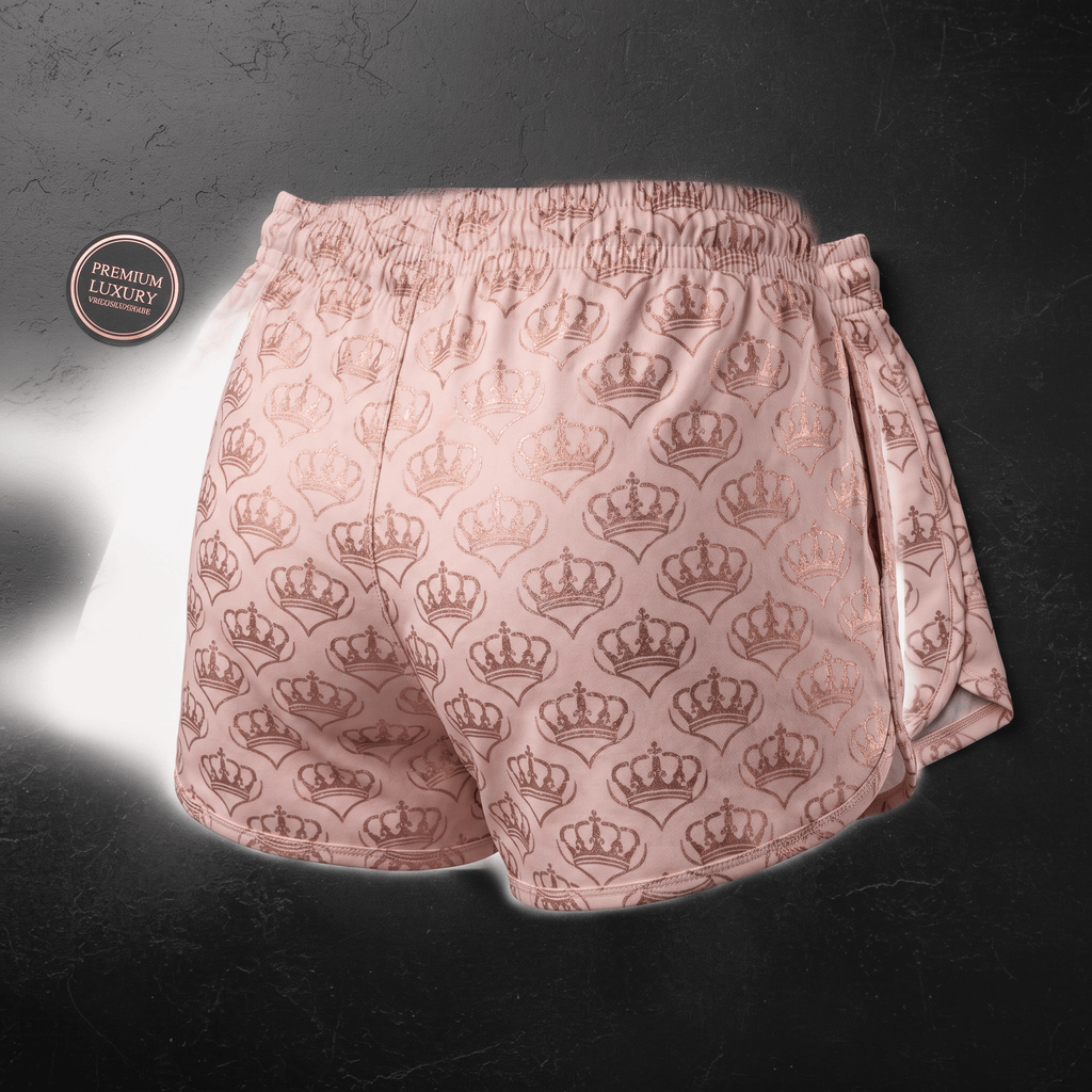 Pink athletic shorts featuring an allover metallic rose gold crown pattern on a dark background.