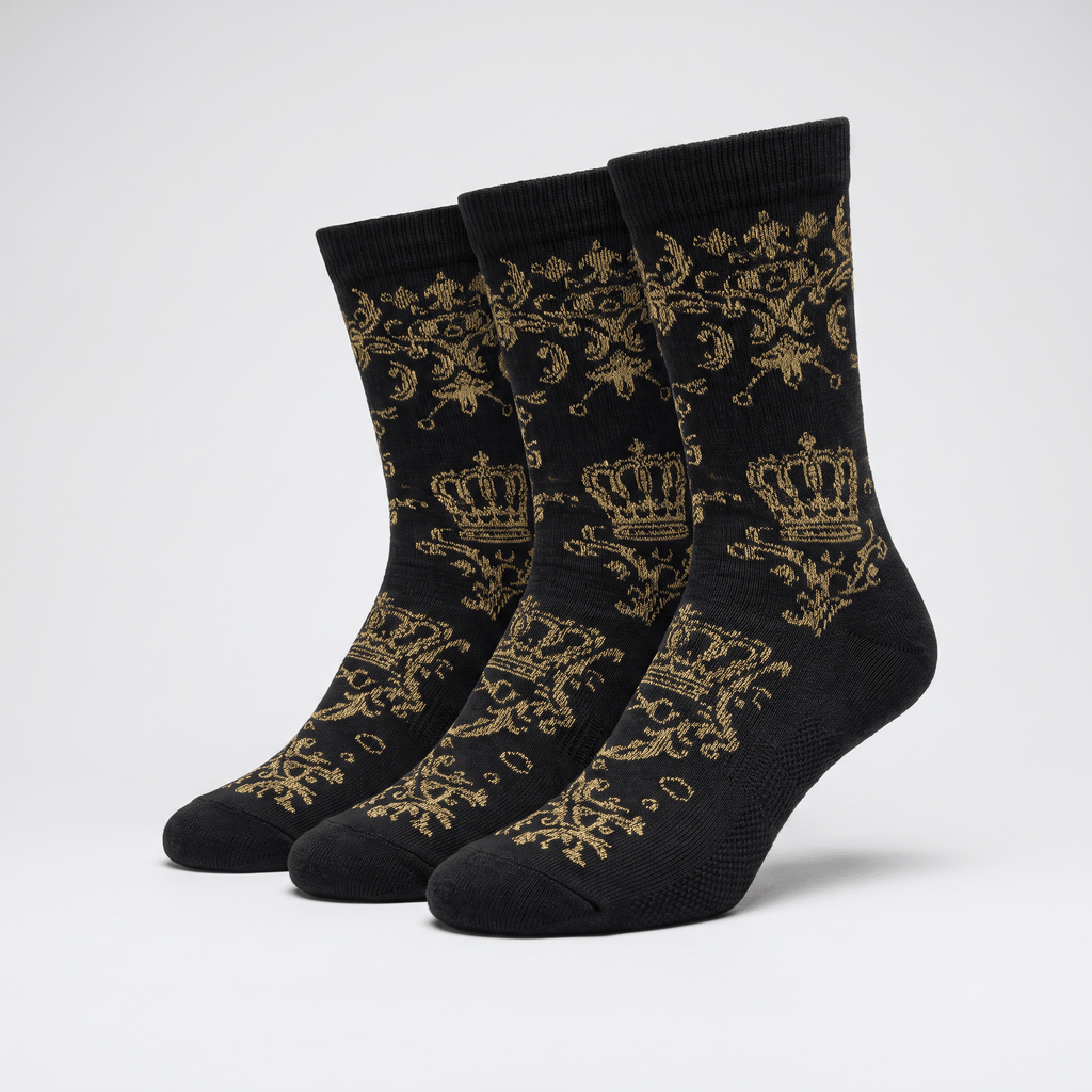 Three black crew socks featuring a gold royal crown and filigree pattern against a light grey background.