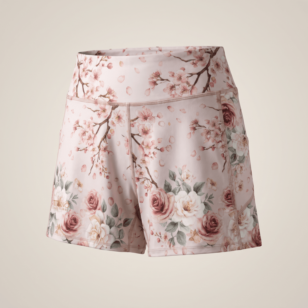 Pink athletic shorts with a cherry blossom and rose floral print, featuring a high waist and side pockets.