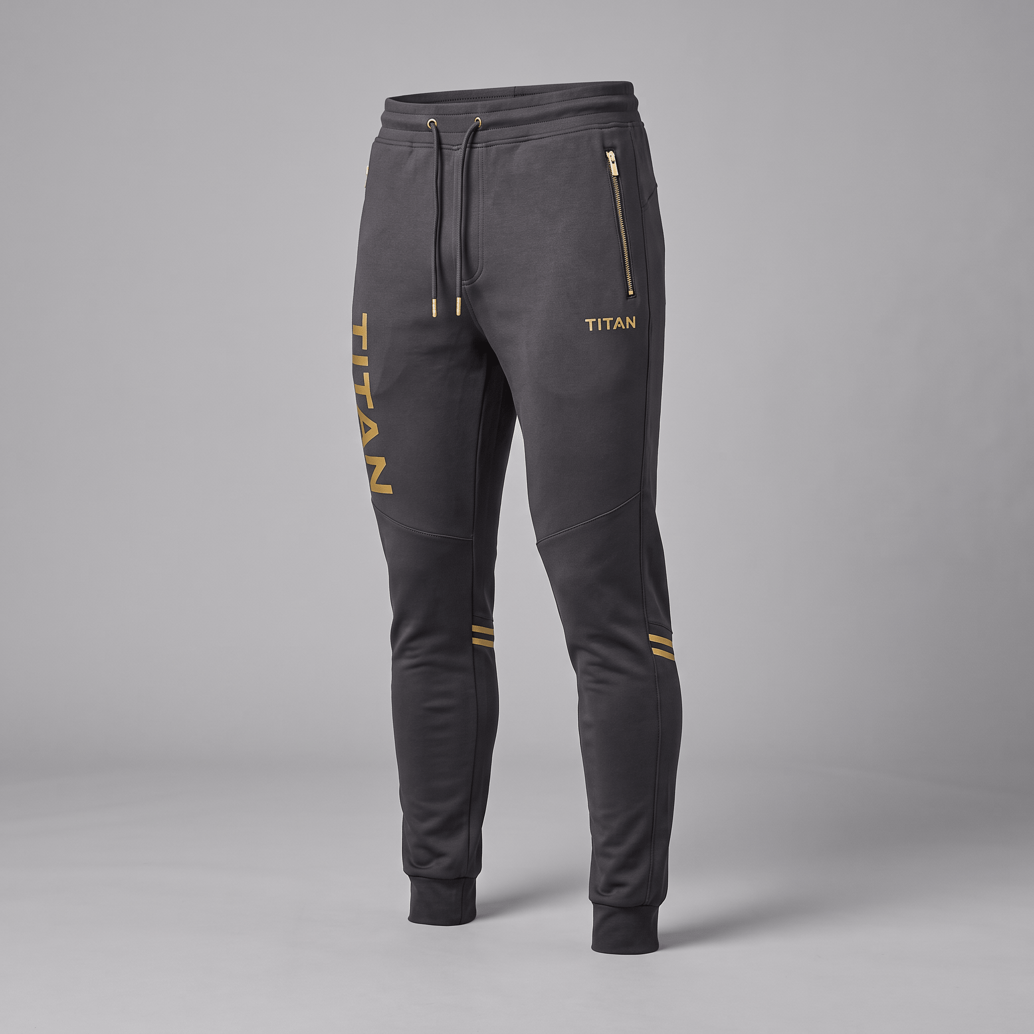 Dark gray Titan athletic sweatpants with gold drawstrings, zipper pockets, and logo print.