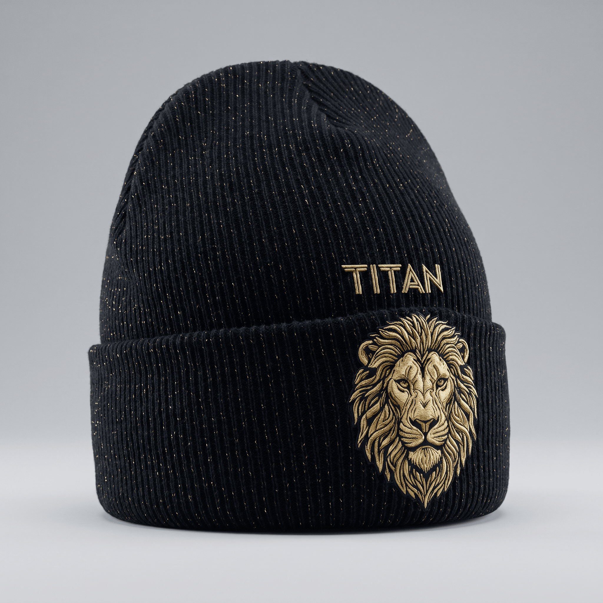 Black ribbed knit beanie with gold metallic flecks, gold lion embroidery, and Titan text on a grey background.