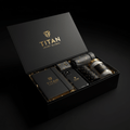Black gift box with gold TITAN logo containing a leather journal, phone case, geometric accessories, and a glass jar.