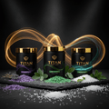 Three TITAN black tubs with gold lids and colored Epsom salts: purple lavender, green eucalyptus, and white peppermint.