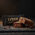 TITAN Keto Protein Bar Dark Chocolate Coconut — dramatic cross-section break shot with dark chocolate drizzle and toasted coconut flakes