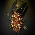 TITAN Keto Nut & Seed Mix Rosemary Sea Salt — rustic overhead pour shot with nuts and seeds cascading, fresh rosemary sprigs and sea salt crystals