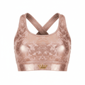 Rose gold metallic sports bra with subtle camo-like pattern, crisscross back straps, and a small gold crown logo.