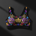 Black high-impact sports bra with gold crowns, purple roses, and colorful gemstone pattern. "TITAN" logo at center.