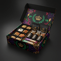 Open Titan athlete box with black food trays, supplement pouches, bottles, and bars on a black patterned background.