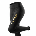 Black high-waisted performance leggings with a vertical gold metallic "TITAN" logo on the right thigh.