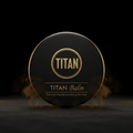 Black, round TITAN Beard Balm tin with gold logo and text, surrounded by wisps of smoke on a dark surface.