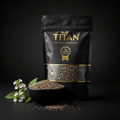 Black pouch of TITAN organic chia seeds with gold branding, next to a black bowl of seeds and small white flowers.