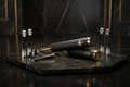 TITAN Crown Edition black and gold toothbrushes on a marble surface with crown logo and white charcoal bristles.