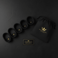 Four black resistance bands, a matching drawstring bag, and a gold-accented box, all with gold crown logos.