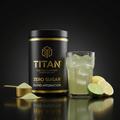 Black and gold TITAN electrolyte powder tub with scoop, glass of citrus hydration mix, and fresh lime and lemon.