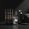 Three black TITAN electrolyte tablet tubes, a glass with a fizzing tablet, and a black water bottle on dark surface.