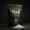 Matte black pouch of TITAN Epsom Salt with gold branding, athletic figure graphic, and a pile of white salt crystals.