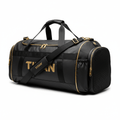 Black TITAN gym duffel bag with gold accents, prominent gold branding, top handles, and a shoulder strap.