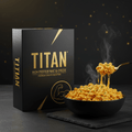 Black box of TITAN High Protein Mac & Cheese next to a steaming black bowl of cheesy macaroni on a slate surface.