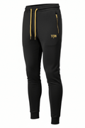 Black TITAN tapered joggers with gold drawstring, matching gold zippered pockets, and embroidered gold logo.