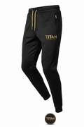 Black Titan Sport Global joggers with gold drawstring, gold logo, zippered pocket, and textured knee panel details.