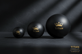 Three matte black massage balls of increasing size, each featuring a gold crown logo and the text "TITAN."