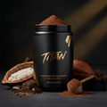 Black jar of TITAN Chocolate Mixed Plant Protein Powder with a scoop, cocoa pods, and chocolate chunks on dark surface.