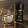 Black canister of Titan NAD+ coffee creamer next to a steaming latte on a dark marble surface with gold coffee beans.