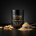 TITAN peanut butter powder in a black jar with gold text, scoop of powder, and peanuts on a black surface.