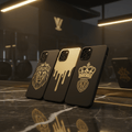 Three premium matte black Titan phone cases with gold lion, crown, and drip designs on a black marble surface.