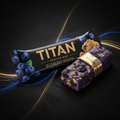 TITAN Blueberry Muffin protein bar with black wrapper, gold text, and purple-glazed bar with blueberries on black.