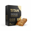 Black and gold TITAN Salted Caramel 12-pack protein bar box with a drizzled caramel protein bar in the foreground.