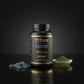 Black bottle of TITAN Spirulina tablets with gold text, next to green tablets, powder, and spirulina on dark surface.