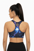 TITAN Sports Bra, Cosmic Burst edition with vibrant blue and purple nebula print and gold crown logo racerback detail.