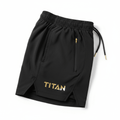 Black TITAN performance shorts with gold logo, side zip pocket, drawstring waist, and vented hem on a white background.