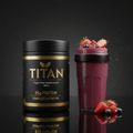 Black tub of TITAN Vegan Berry Meal Replacement with gold text, beside a berry smoothie in a black-rimmed glass.