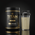 TITAN Vegan Vanilla meal replacement tub with gold lettering next to a shaker bottle of prepared shake on black surface.
