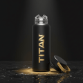Matte black 32oz insulated Titan water bottle with gold logo, ice cubes at the opening, and a matching carry lid.