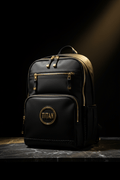 Black TITAN Elite performance backpack with gold zippers and circular gold logo, set on a dark marble surface.