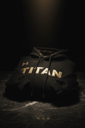Black Titan Sherpa hoodie with gold Under Armour logo and TITAN lettering, featuring ribbed cuffs and gold aglets.